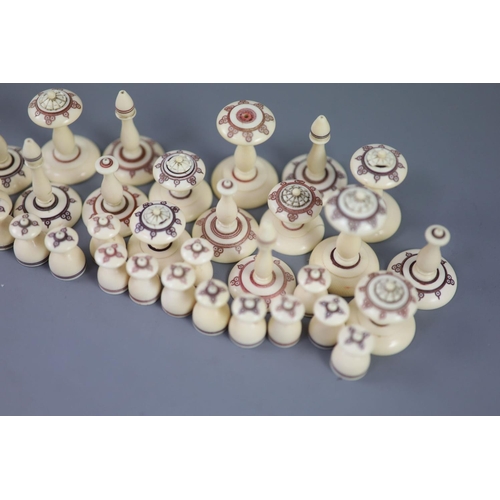 22 - A 19th century Muslim ivory chess set, the two sides with engraved red and brown geometric motifs, k... 