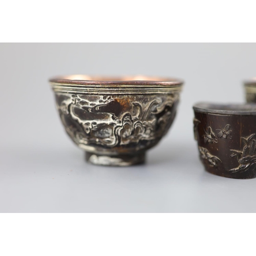 245 - A pair of Chinese coconut 'landscape' cups and a similar peach-shaped cup, 18th/19th century, the pa... 