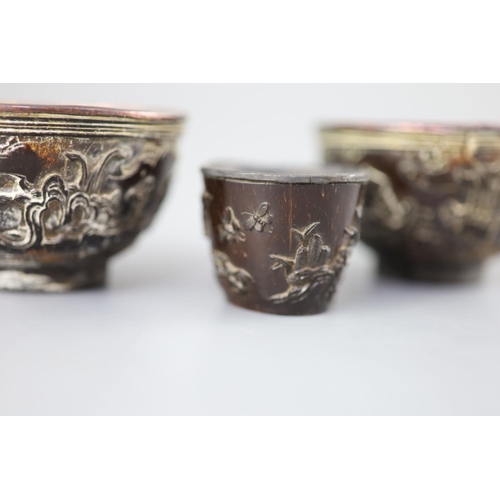 245 - A pair of Chinese coconut 'landscape' cups and a similar peach-shaped cup, 18th/19th century, the pa... 