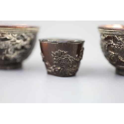 245 - A pair of Chinese coconut 'landscape' cups and a similar peach-shaped cup, 18th/19th century, the pa... 