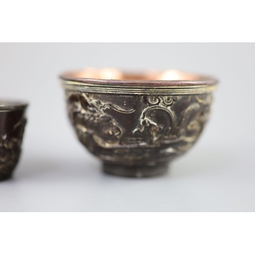 245 - A pair of Chinese coconut 'landscape' cups and a similar peach-shaped cup, 18th/19th century, the pa... 