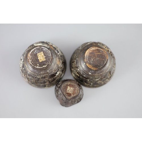 245 - A pair of Chinese coconut 'landscape' cups and a similar peach-shaped cup, 18th/19th century, the pa... 