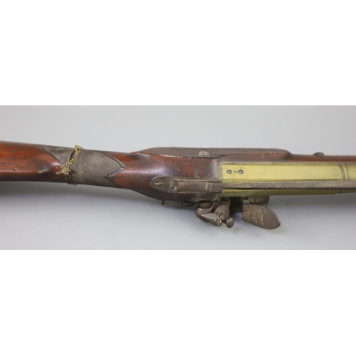 25 - A late 18th century brass barrelled flintlock blunderbuss, by Jones, with chequered mahogany stock, ... 