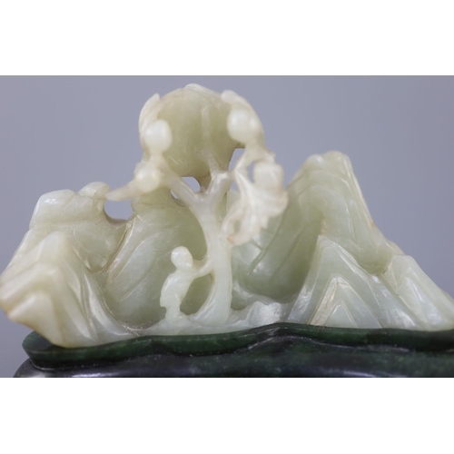 255 - A Chinese pale celadon jade boulder carving, Qing dynasty, carved in high relief and openwork with a... 