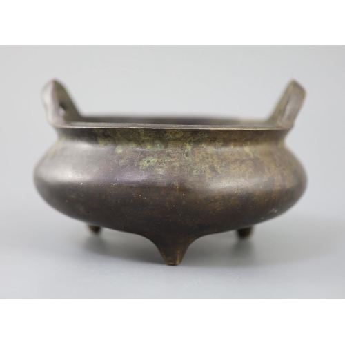 287 - A Chinese bronze tripod censer, Xuande mark but 19th century, with a pair of high-looped handles, on... 