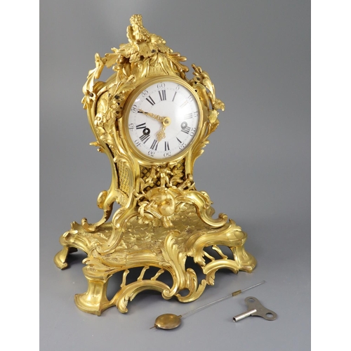 295 - A mid 18th century French ormolu mantel clock, with ornate pierced foliate scroll case and enamelled... 