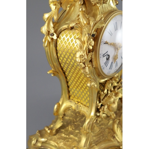 295 - A mid 18th century French ormolu mantel clock, with ornate pierced foliate scroll case and enamelled... 