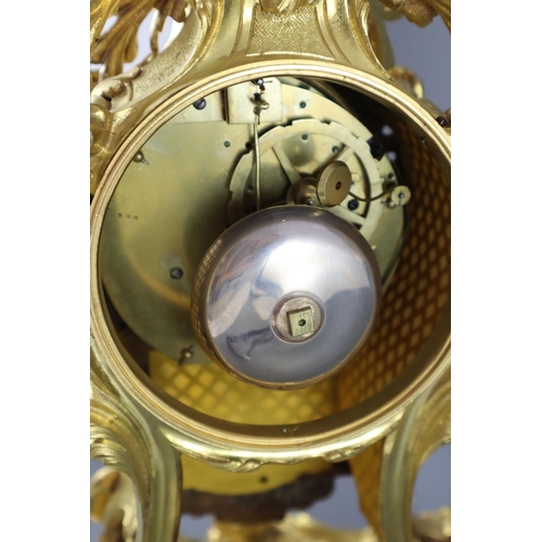 295 - A mid 18th century French ormolu mantel clock, with ornate pierced foliate scroll case and enamelled... 