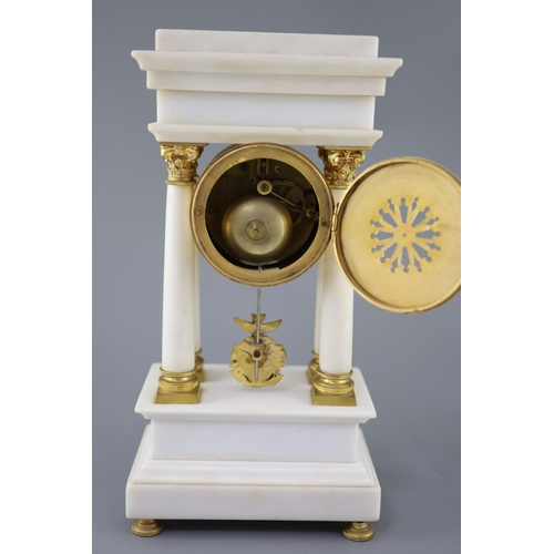 297 - A Louis XVI style ormolu mounted white marble clock garniture, with Portico clock flanked by a pair ... 