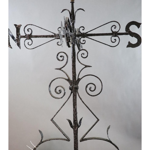 308 - A large Victorian black painted wrought iron weather vane, surmounted with a running hound, with ind... 