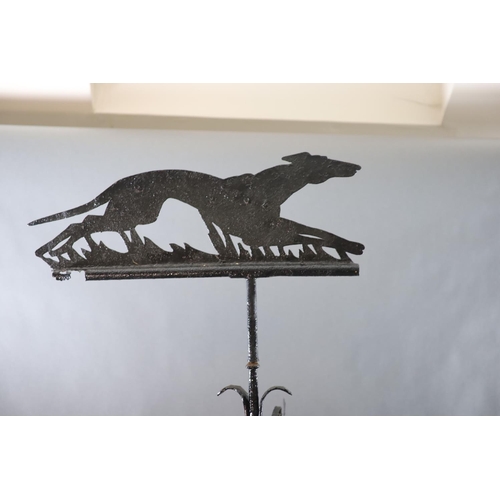 308 - A large Victorian black painted wrought iron weather vane, surmounted with a running hound, with ind... 