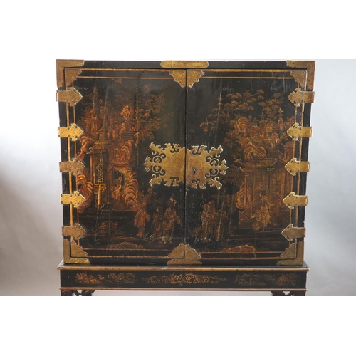 313 - A late 17th century japanned cabinet on later stand with two doors decorated with a chinoiserie land... 