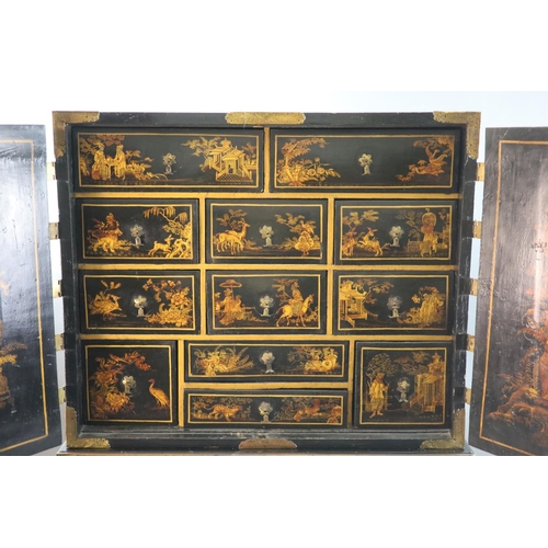 313 - A late 17th century japanned cabinet on later stand with two doors decorated with a chinoiserie land... 