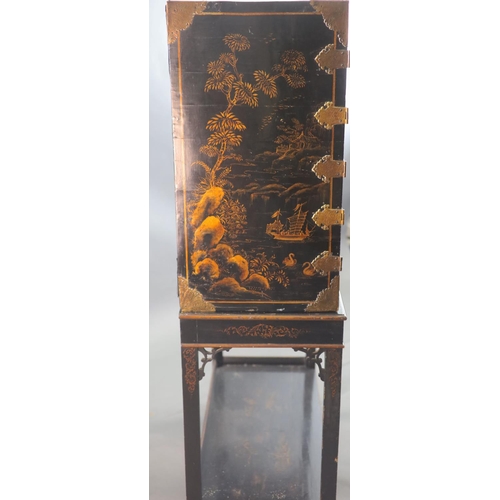 313 - A late 17th century japanned cabinet on later stand with two doors decorated with a chinoiserie land... 