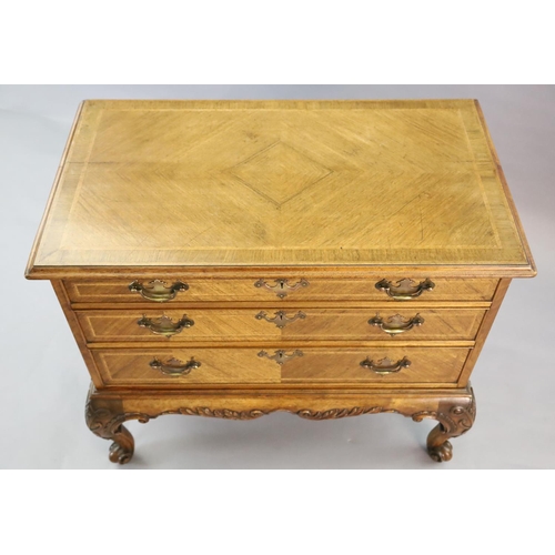 320 - A Georgian style crossbanded walnut chest of three graduated long drawers, with quarter veneered top... 