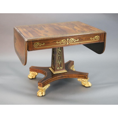 334 - A Regency brass inset rosewood sofa table, the top with D shaped flaps inlaid with a band of scrolli... 