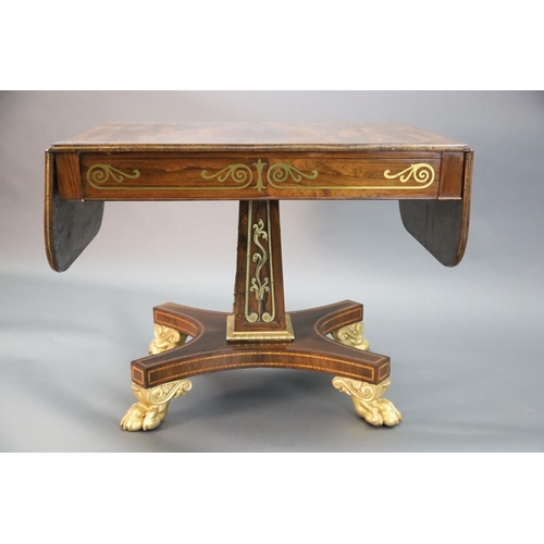 334 - A Regency brass inset rosewood sofa table, the top with D shaped flaps inlaid with a band of scrolli... 