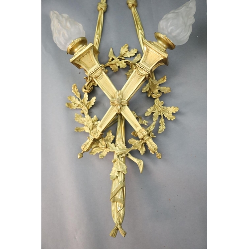 345 - A pair of early 20th century Louis XVI style ormolu wall lights, with ribbon and oak branch backs, t... 