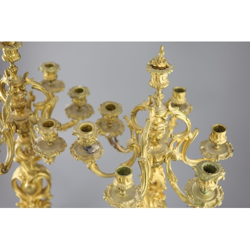 35 - A pair of late 19th century French Louis XV style ormolu seven light candelabra, with foliate scroll... 