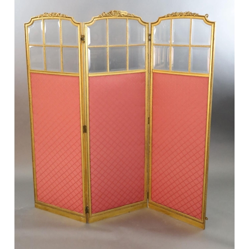 354 - An early 20th century French giltwood three fold dressing screen, carved with ribbons and laurel lea... 