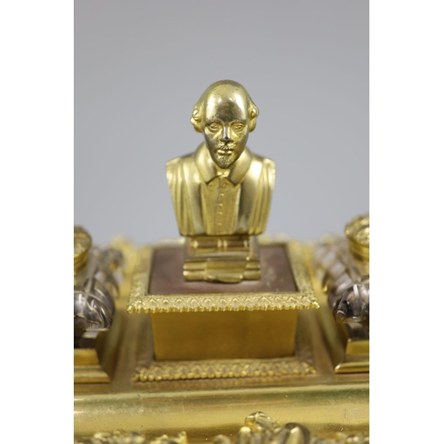 36 - A Victorian ormolu ink stand, the central wafer box applied with a bust of a Shakespeare and flanked... 