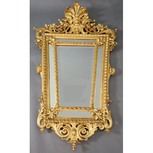 364 - A Louis XIV style carved giltwood wall mirror, with putto mask, fruit and foliate scroll crest, tape... 