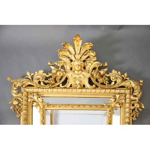 364 - A Louis XIV style carved giltwood wall mirror, with putto mask, fruit and foliate scroll crest, tape... 