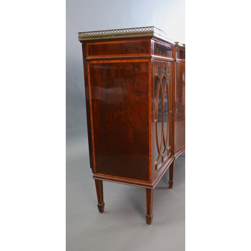 370 - An Edwardian rosewood banded mahogany serpentine dwarf bookcase, with brass gallery and central door... 