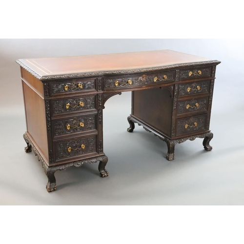 373 - An Edwardian foliate carved mahogany serpentine kneehole desk, with gilt brown skiver, central bowfr... 