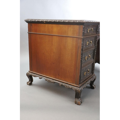 373 - An Edwardian foliate carved mahogany serpentine kneehole desk, with gilt brown skiver, central bowfr... 