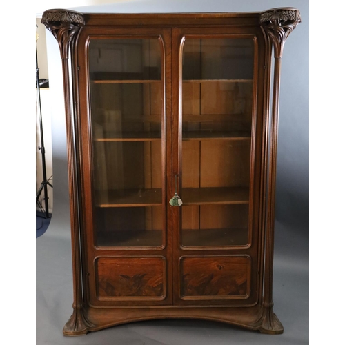 374 - An Art Nouveau walnut and marquetry vitrine by Majorelle, with foliate carved and pierced columns fl... 