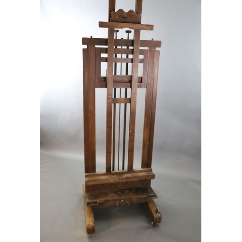 376 - A Roberson & Co oak studio easel, with twin cranked telescopic height adjustment and ivory label giv... 