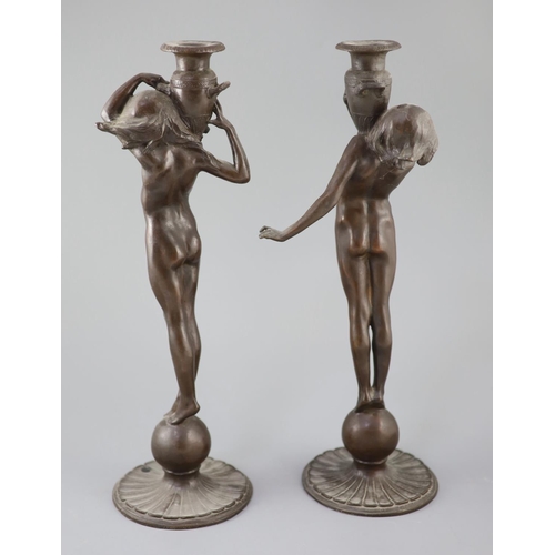 39 - After Edward Francis McCartan (1879-1947). A pair of Art Nouveau bronze candlesticks, modelled as nu... 