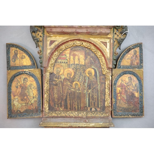 418 - A 19th century Russian tempera on wood triptych icon, c.1800 with floral and bird carved crest, the ... 