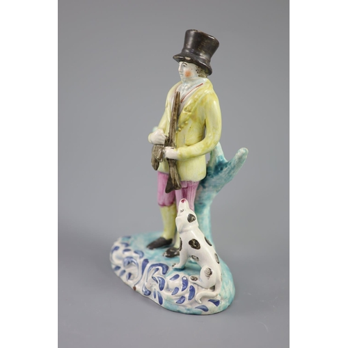 44 - A Staffordshire pearlware group of a huntsman with dog and gun, c.1820-30, on a turquoise and blue h... 