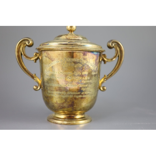 506 - An Edwardian silver gilt-lidded two handled presentation cup and cover, by R & S Garrard and Co. wit... 