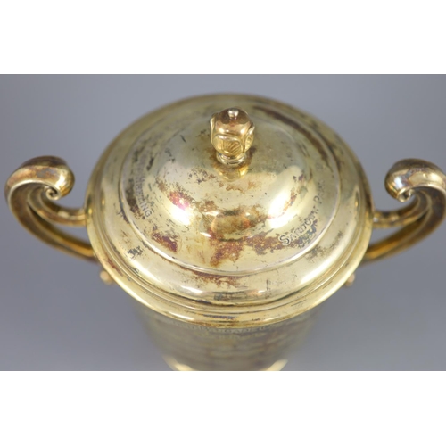 506 - An Edwardian silver gilt-lidded two handled presentation cup and cover, by R & S Garrard and Co. wit... 