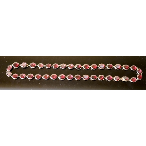 538 - An early 19th century gold and garnet set necklace, set with thirty six oval cut garnets, 38cm, gros... 