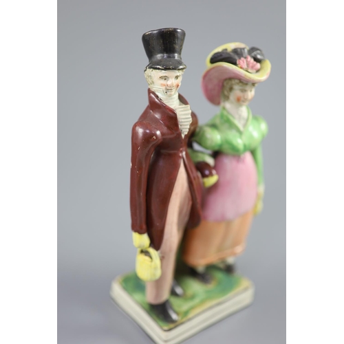 54 - A Staffordshire pearlware group of a Dandy and Dandizette, c.1820, standing before rockwork on a bla... 