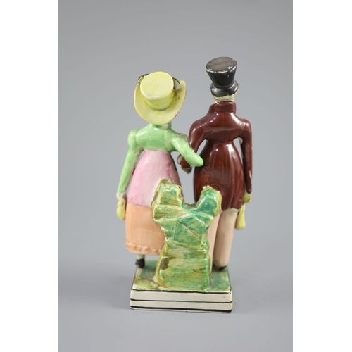 54 - A Staffordshire pearlware group of a Dandy and Dandizette, c.1820, standing before rockwork on a bla... 