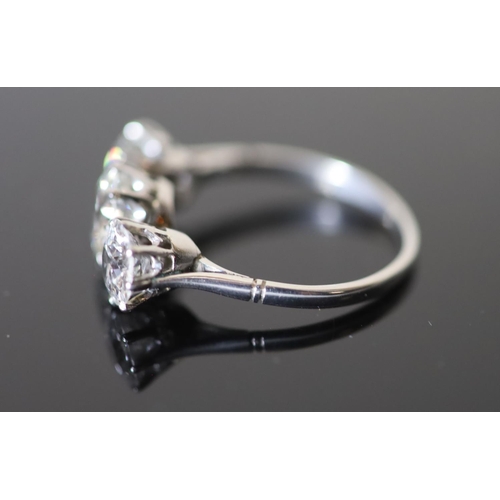 591 - A platinum and three stone diamond ring, the central stone weighing approximately 1.20ct and the two... 