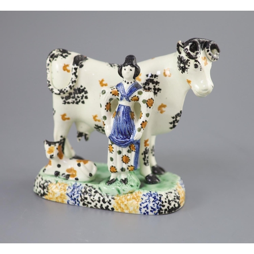 61 - A Yorkshire Prattware 'cow and milkmaid' group, probably Mexborough, c.1820, with sponged decoration... 