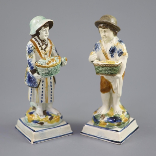 66 - A pair of Prattware figures of fruit and biscuit street vendors, c.1790-1800, on square bases, pearl... 