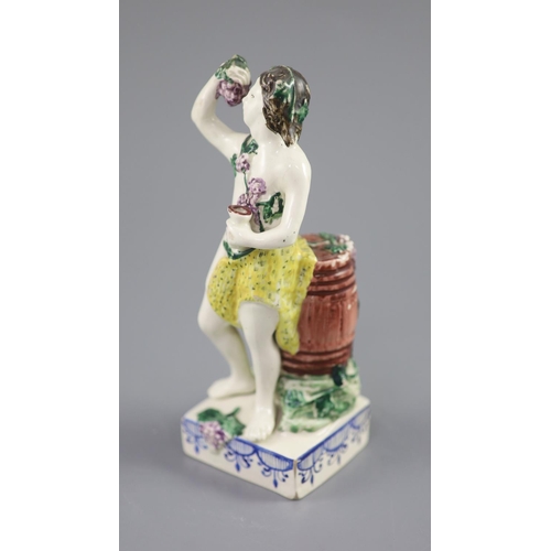 68 - An enamelled creamware figure of Bacchus, attributed Leeds Pottery, c.1790-1800, standing by wine ba... 