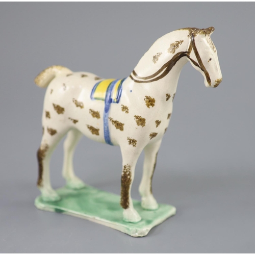 70 - Attributed to St. Anthony Pottery, Newcastle, a pearlware figure of a racehorse with yellow saddle, ... 