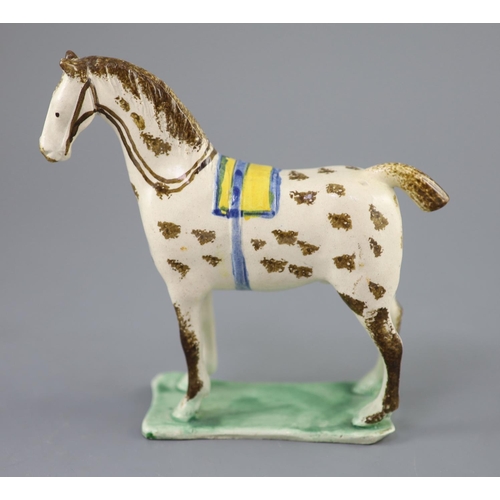 70 - Attributed to St. Anthony Pottery, Newcastle, a pearlware figure of a racehorse with yellow saddle, ... 