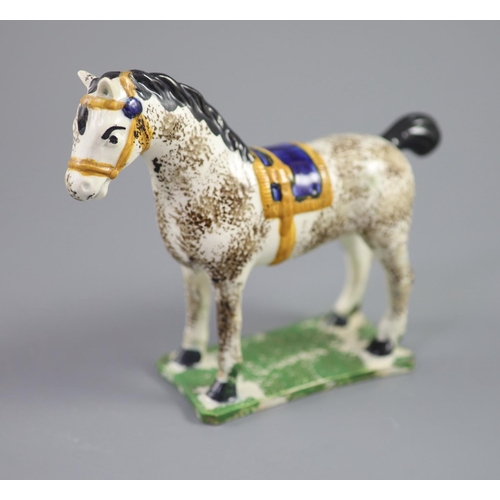 71 - A North Country pearlware figure of a dapple horse with blue saddle, c.1800-20 on a slab base, 14.5c... 