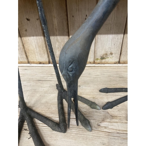 10 - A pair of patinated cast metal garden cranes, larger 91cm high