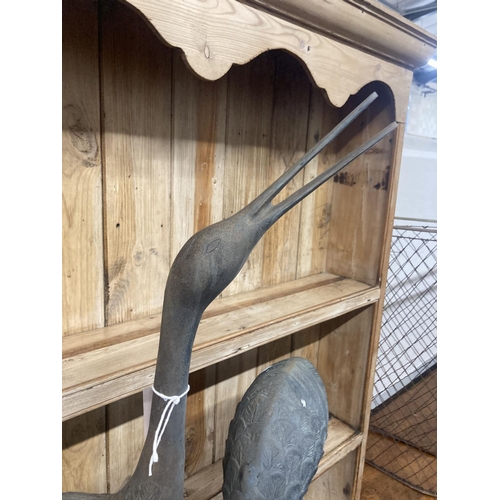 10 - A pair of patinated cast metal garden cranes, larger 91cm high
