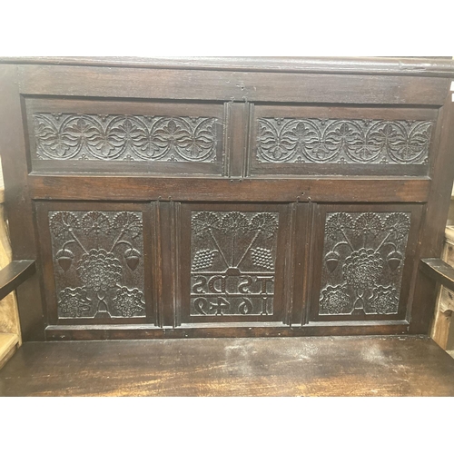 12 - A 19th century oak settle incorporating 17th century panels, width 137cm, depth 44cm, height 131cm... 